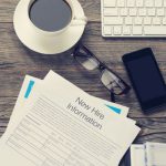 job application on coffee table with coffee glasses and phone