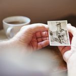elderly person looking at photo of late spouse